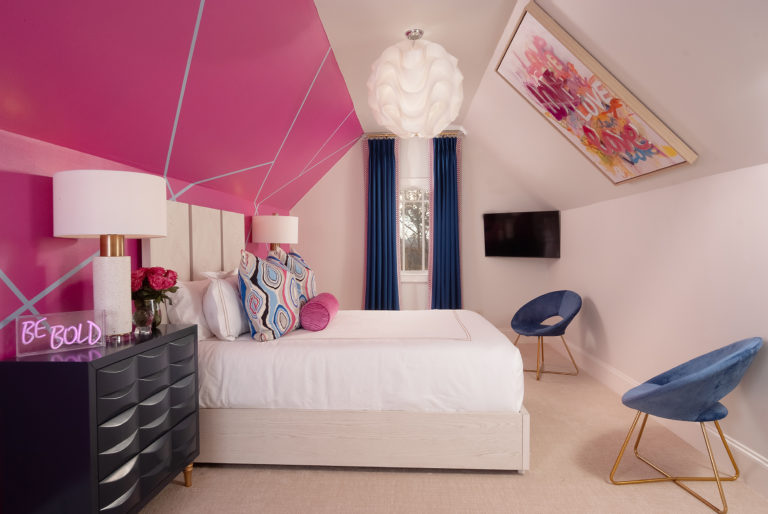 pink kids bedroom with chairs and artwork