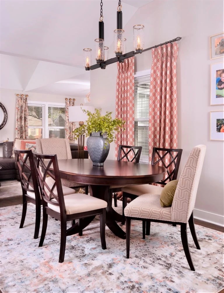 Dining room with coral-colored chairs and matching curtains