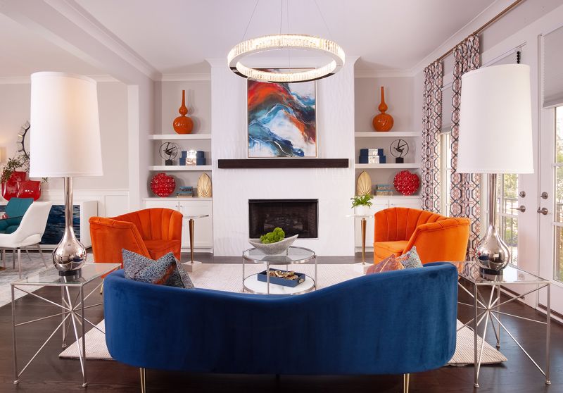 rich blue couch set against bold orange chairs showcasing maximalist summer interior design in Cincinnati