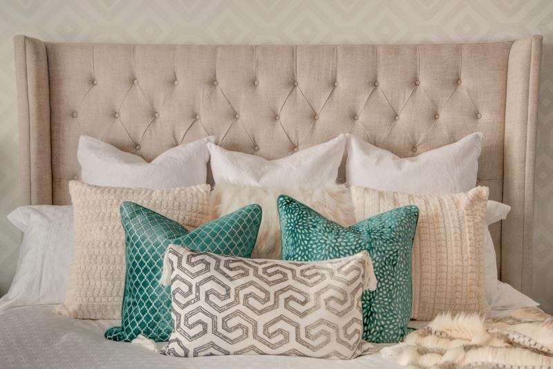 Colorful Spread of Pillows on a White Bed