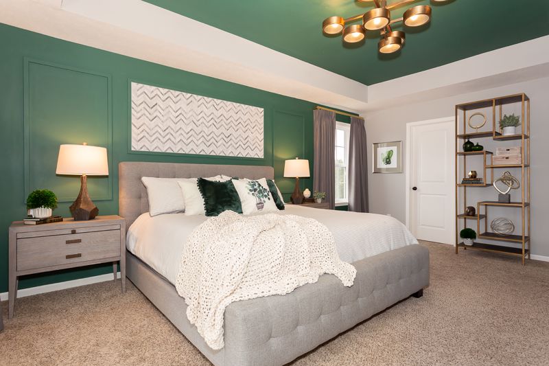 bed with white bedding in a green room