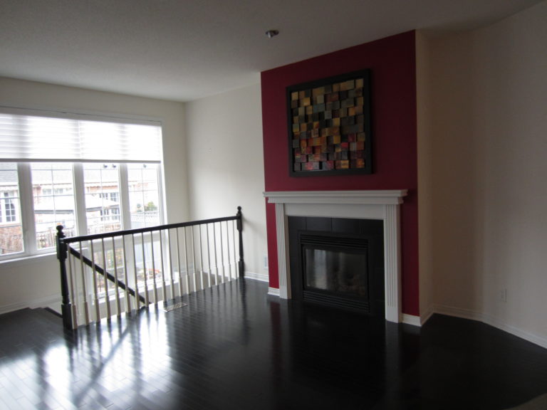 empty loft with red fireplace and hardwood floors