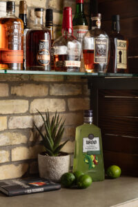 Liquor shelf set against brick wall in an industrial style living room