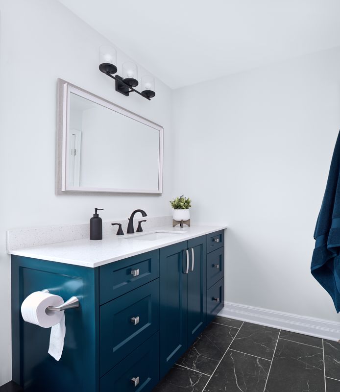 deep blue vanity cabinets in plain white bathroom showcasing minimalism