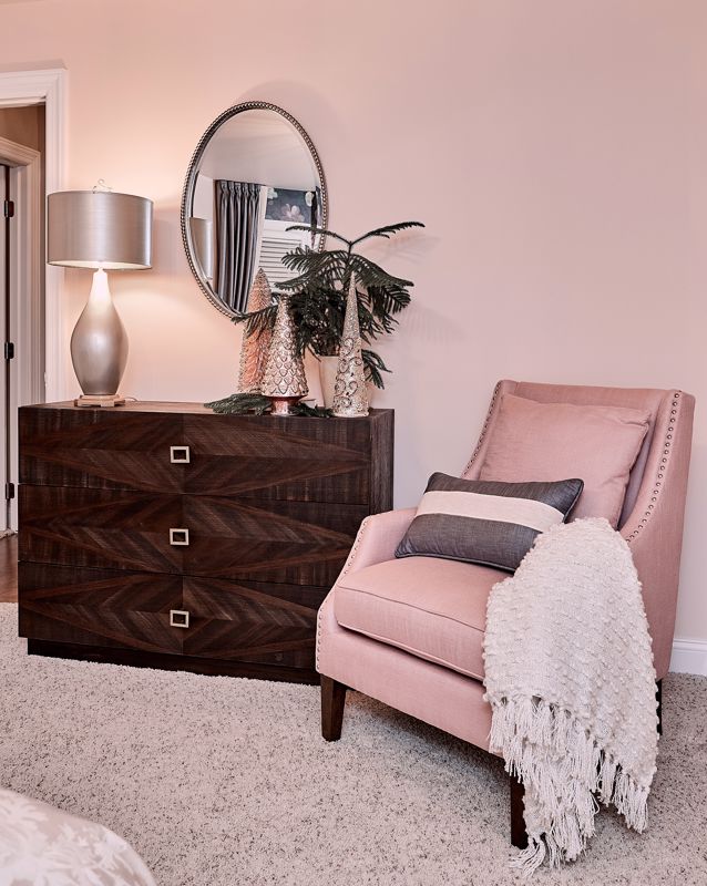 blush pink chair and dark mahogany dresser showcasing a chic interior design style in cincinnati