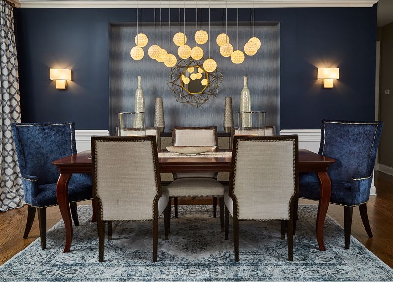 beige and blue dining room interior design with dark brown table and modern yellow hanging lights