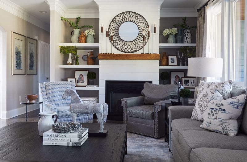 gray and black furniture set against cozy reading nook white walls with plant décor and fireplace showcasing a hygge interior design style in the summer
