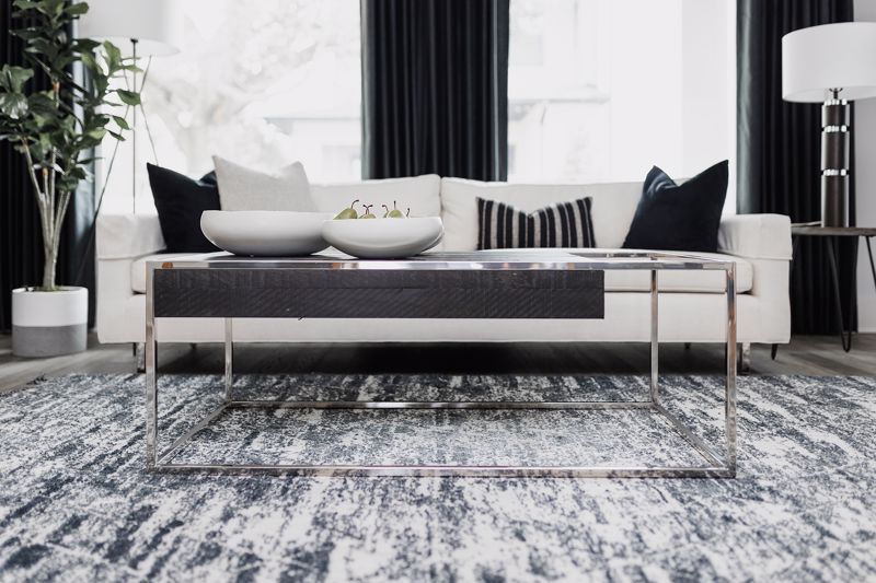 textured rug and modern metal coffee table set against black and white furniture interior design Cincinnati