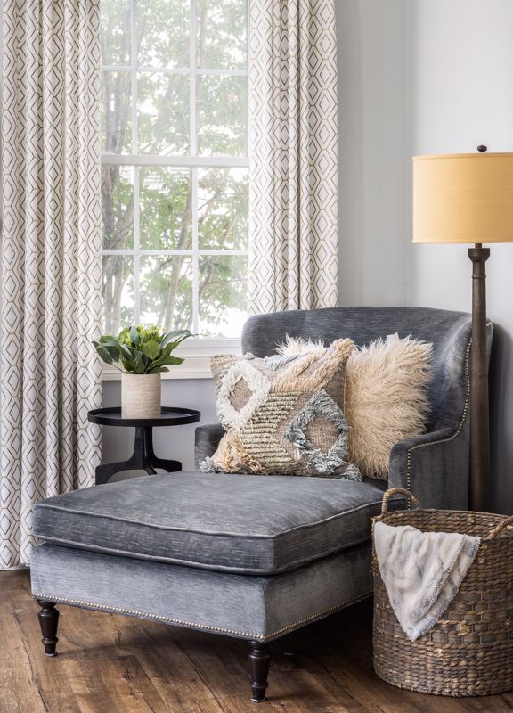 gray divan with furry pillows set against pattern curtains showcasing variety of materials in biophilic design