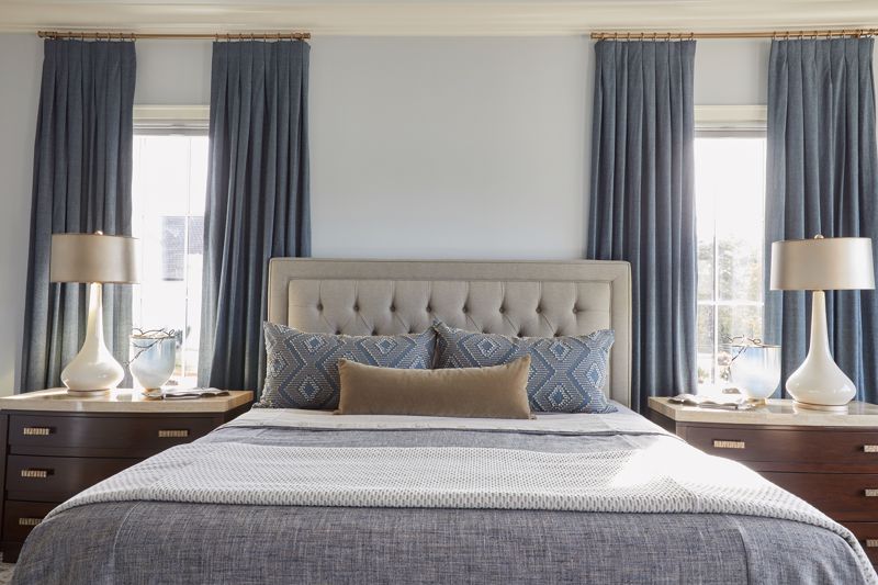 custom upholstered headboard for gray bed set against dark blue curtains showcasing interior design in Cincinnati, OH