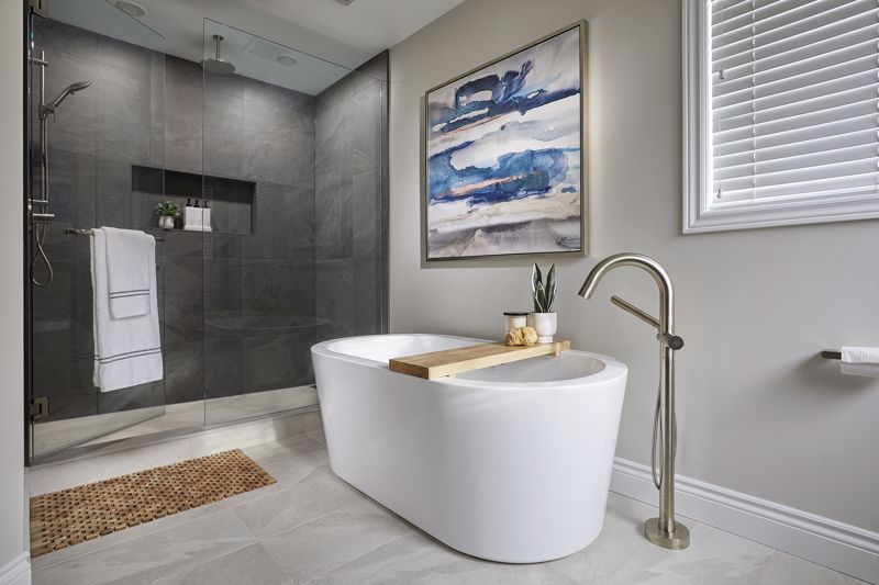 porcelain bathtub set against walk-in shower and abstract painting decor showcasing spa-inspired interior design in Cincinnati, OH 