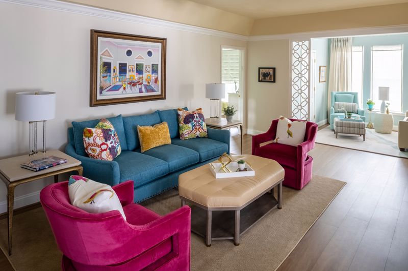 hot pink chairs with blue couch and colorful pillows showcasing maximalist interior design for a living room in Cincinnati