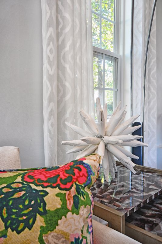 bright colorful pillow print and white spiked decoration set against gray printed curtains for maximalist interior decorating in Cincinnati OH